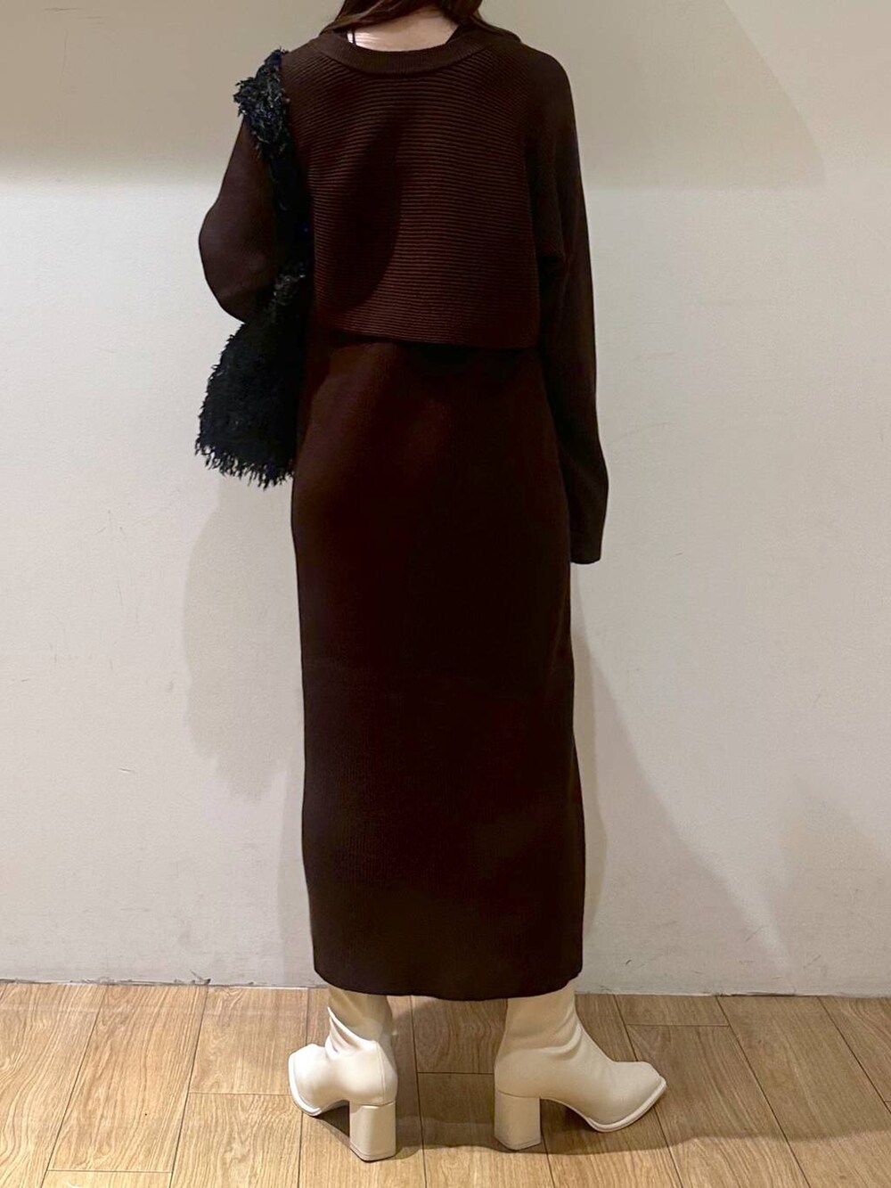 ブラック系のタンクトップ、ブラウン系のワンピース、ホワイト系のパンプスを着用したレディースの冬コーディネートの2枚目の写真