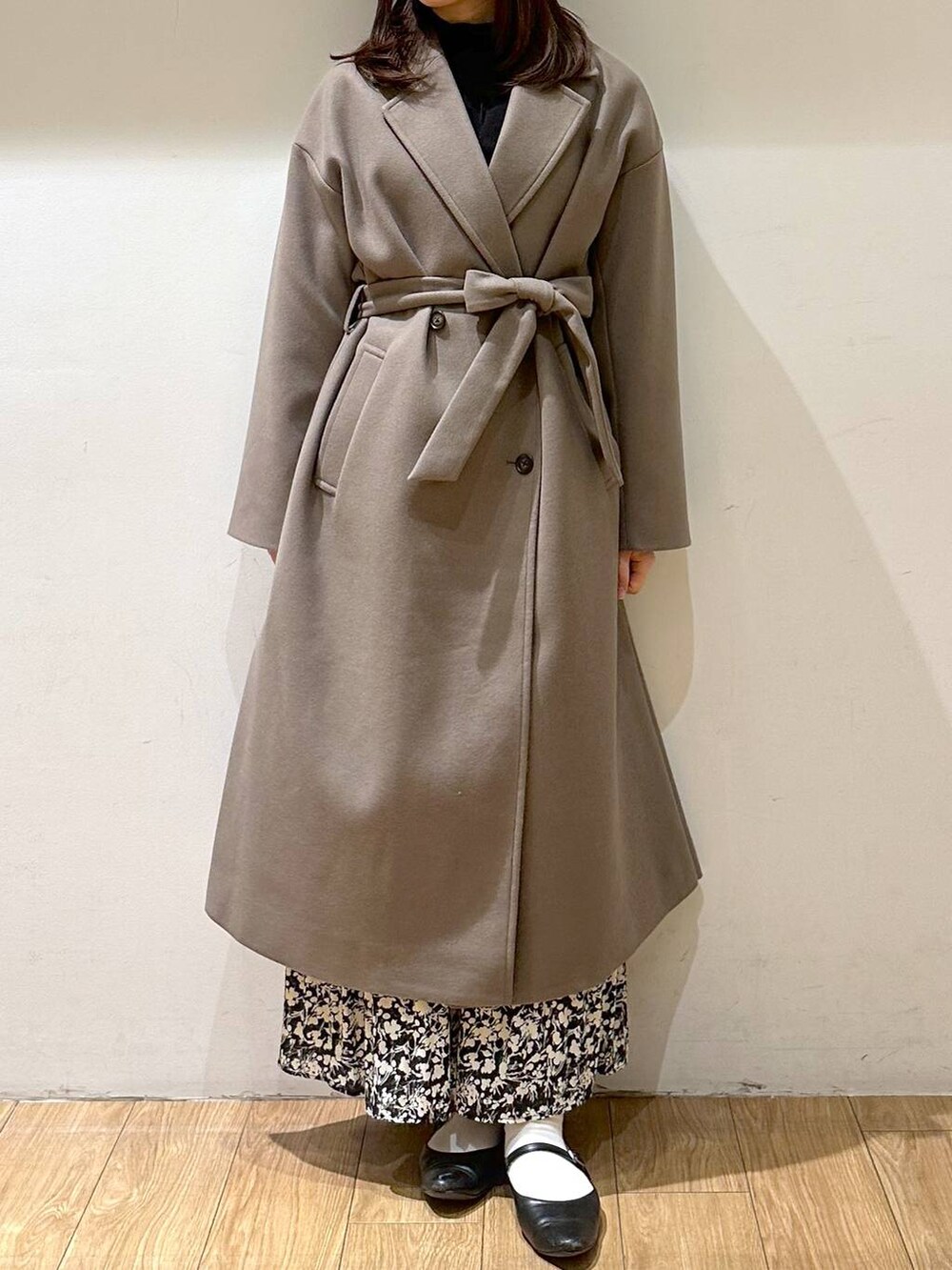 ブラック系のパンプス、ブラウン系のトレンチコート、ブラック系のニット/セーターを着用したレディースの冬コーディネートの3枚目の写真