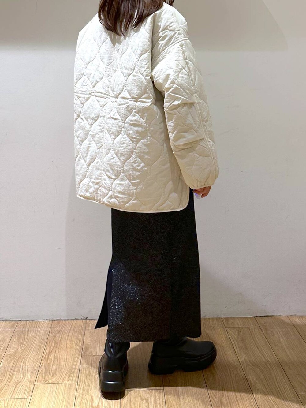 ホワイト系のブルゾン、ブラック系のブーツ、ブラック系のスカートを着用したレディースの冬コーディネートの4枚目の写真