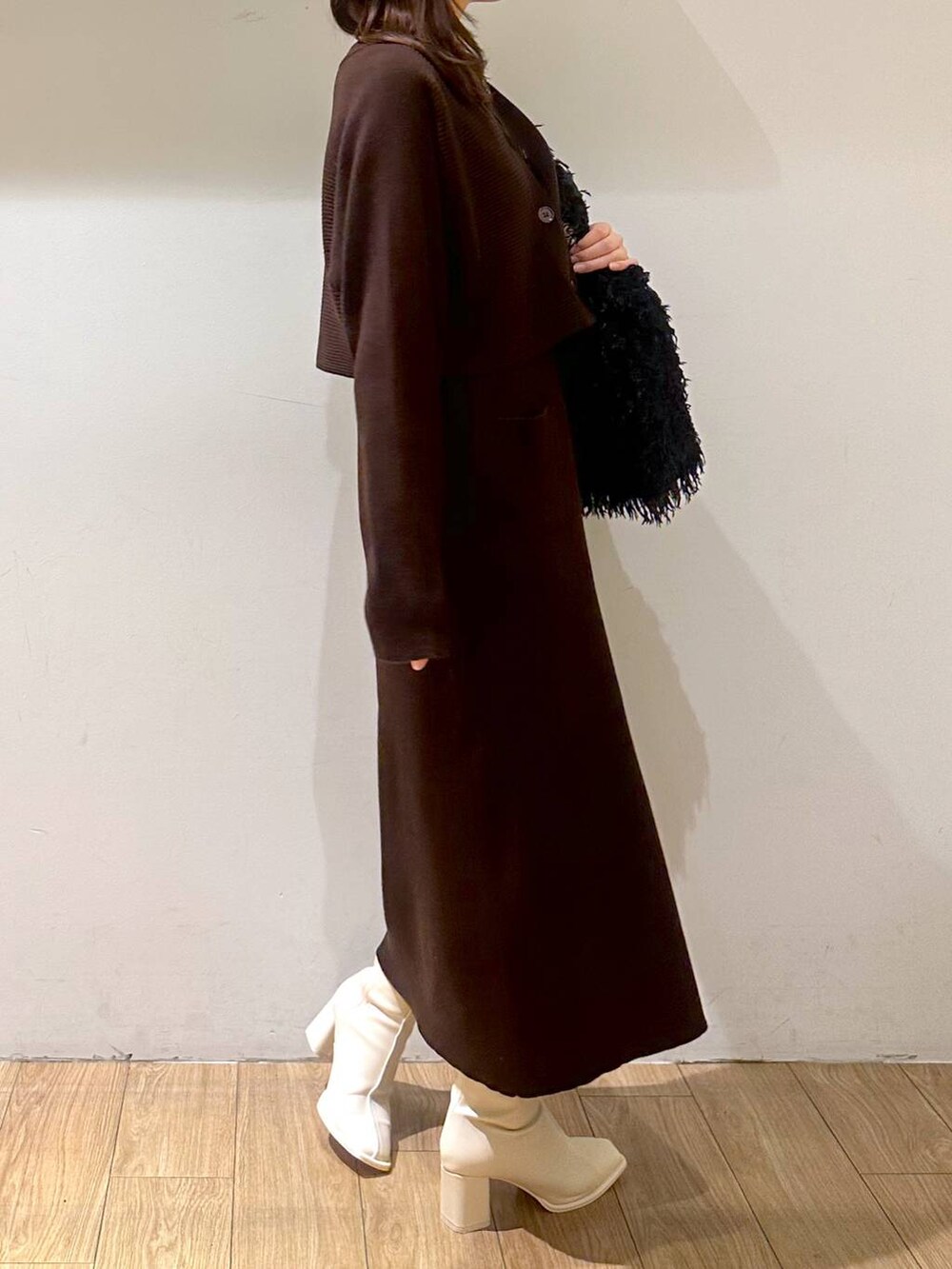 ブラック系のタンクトップ、ブラウン系のワンピース、ホワイト系のパンプスを着用したレディースの冬コーディネートの3枚目の写真