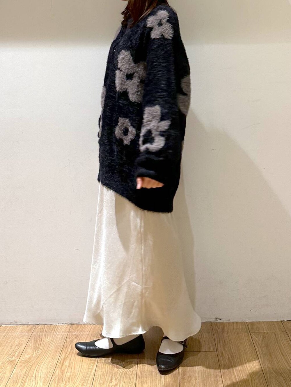 ブラック系のパンプス、ブラック系のニット/セーター、ホワイト系のスカートを着用したレディースの冬コーディネートの3枚目の写真