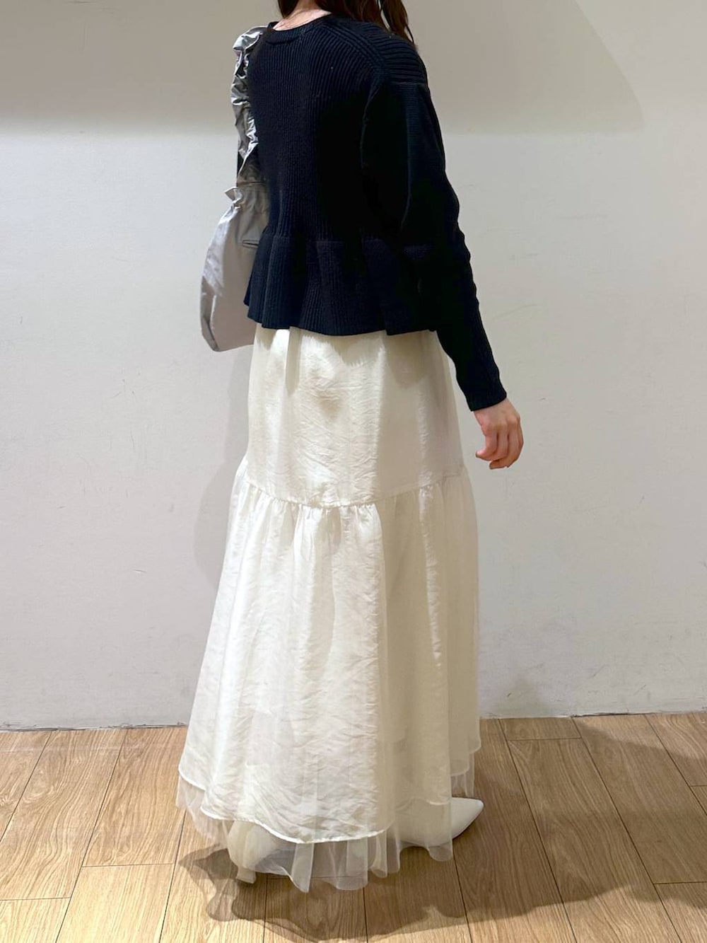 ホワイト系のブーツ、ホワイト系のスカート、グレー系のトートバッグを着用したレディースの冬コーディネートの3枚目の写真