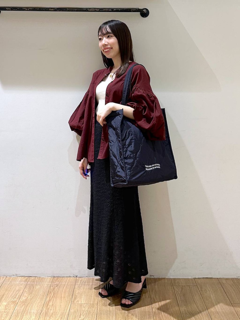 ホワイト系のタンクトップ、ブラック系のサンダル、ブラック系のスカートを着用したレディースの夏コーディネートの2枚目の写真