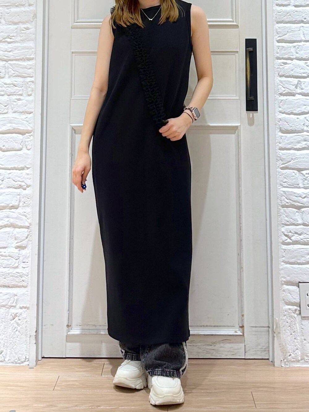 ブラック系のデニムパンツ、ブラック系のワンピース、ホワイト系のスニーカーを着用したレディースの夏コーディネートの2枚目の写真