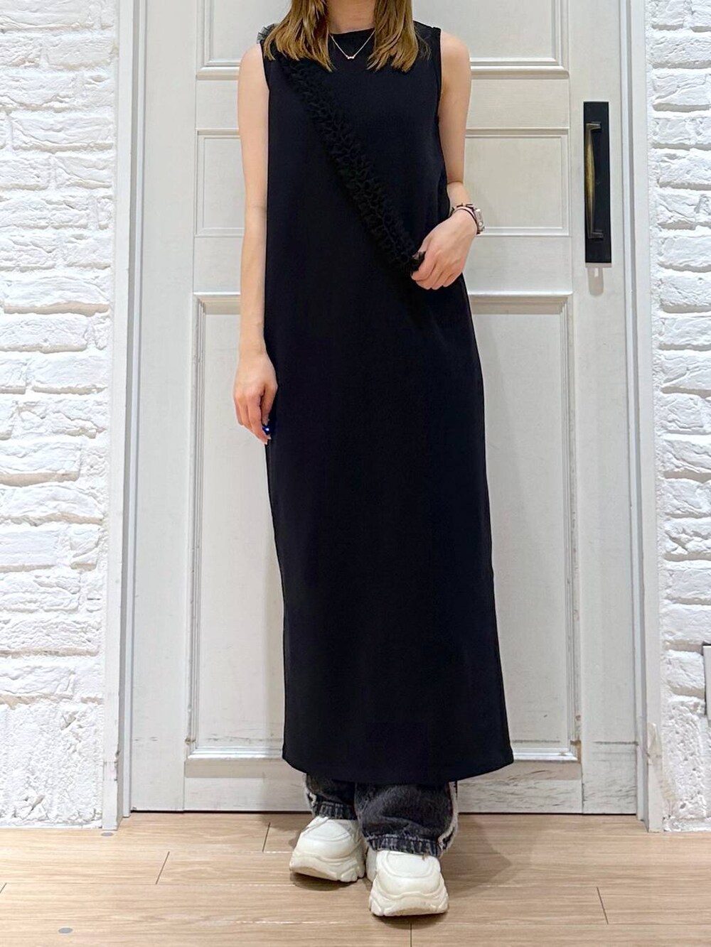 ブラック系のデニムパンツ、ブラック系のワンピース、ホワイト系のスニーカーを着用したレディースの夏コーディネートの5枚目の写真