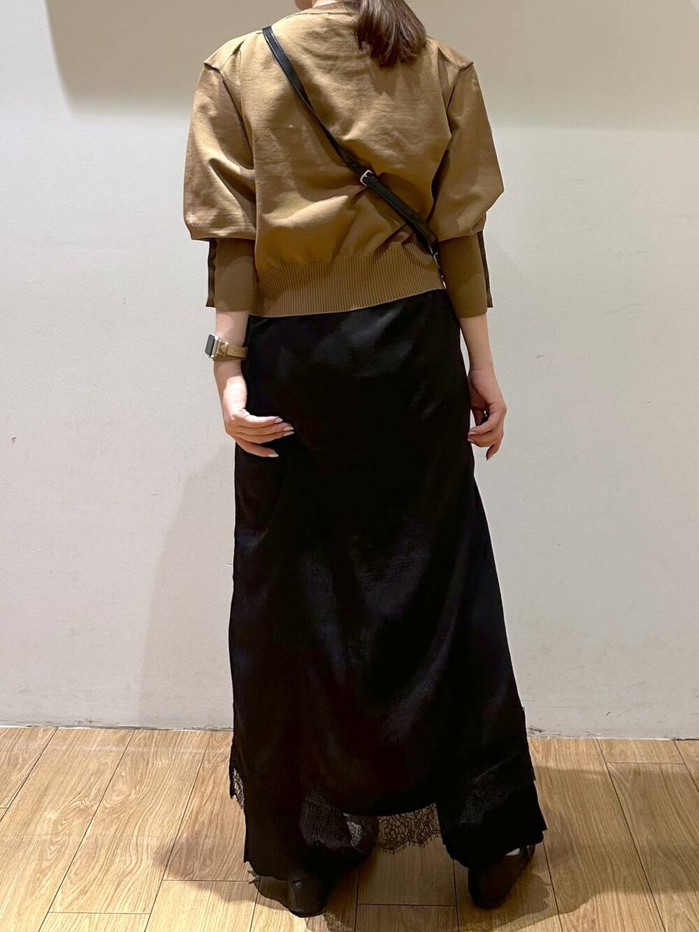 ブラック系のパンプス、ブラック系のワンピース、ベージュ系のニット/セーターを着用したレディースの秋コーディネートの4枚目の写真