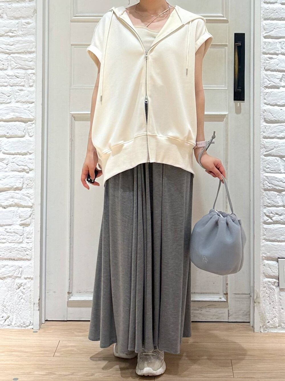 ベージュ系のキャミソール、グレー系のショルダーバッグ、グレー系のスカートを着用したレディースの夏コーディネートの2枚目の写真