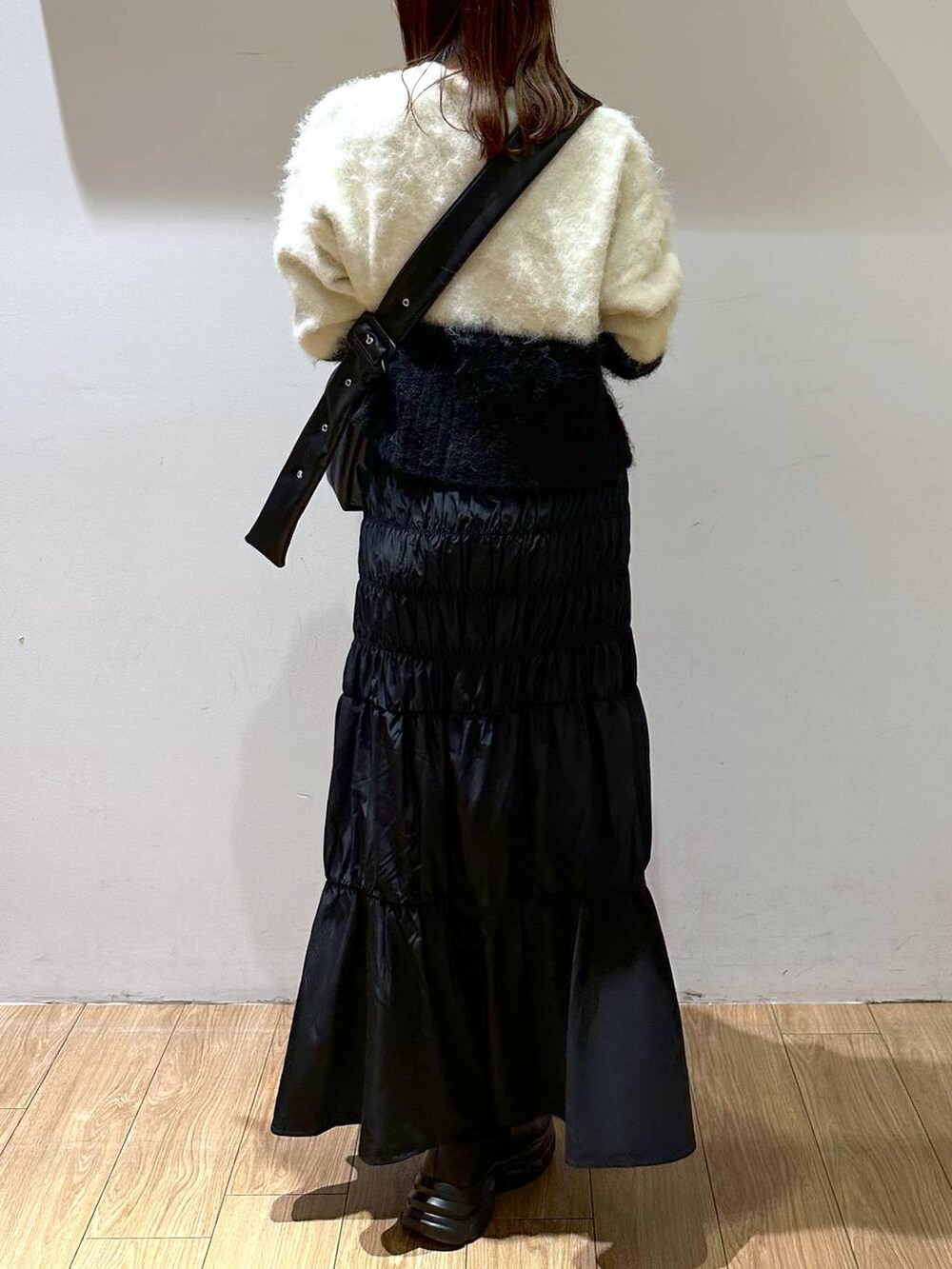 ホワイト系のカーディガン/ボレロ、ブラック系のショルダーバッグ、ブラック系のブーツを着用したレディースの秋コーディネートの4枚目の写真
