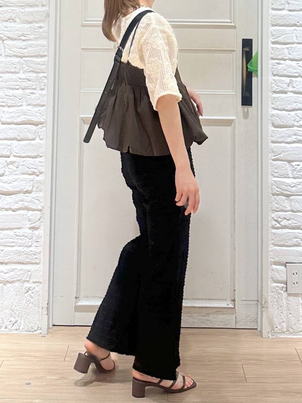 ブラウン系のキャミソール、ブラウン系のサンダル、ブラック系のショルダーバッグを着用したレディースの春コーディネートの3枚目の写真