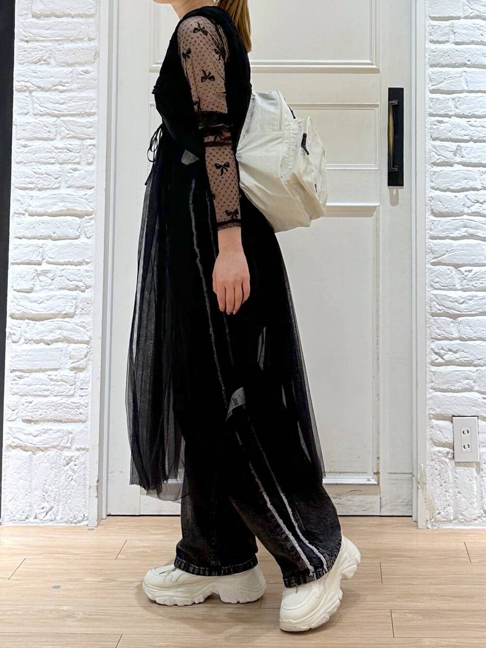 ブラック系のデニムパンツ、ホワイト系のスニーカー、ブラック系のTシャツ/カットソーを着用したレディースの秋コーディネートの3枚目の写真