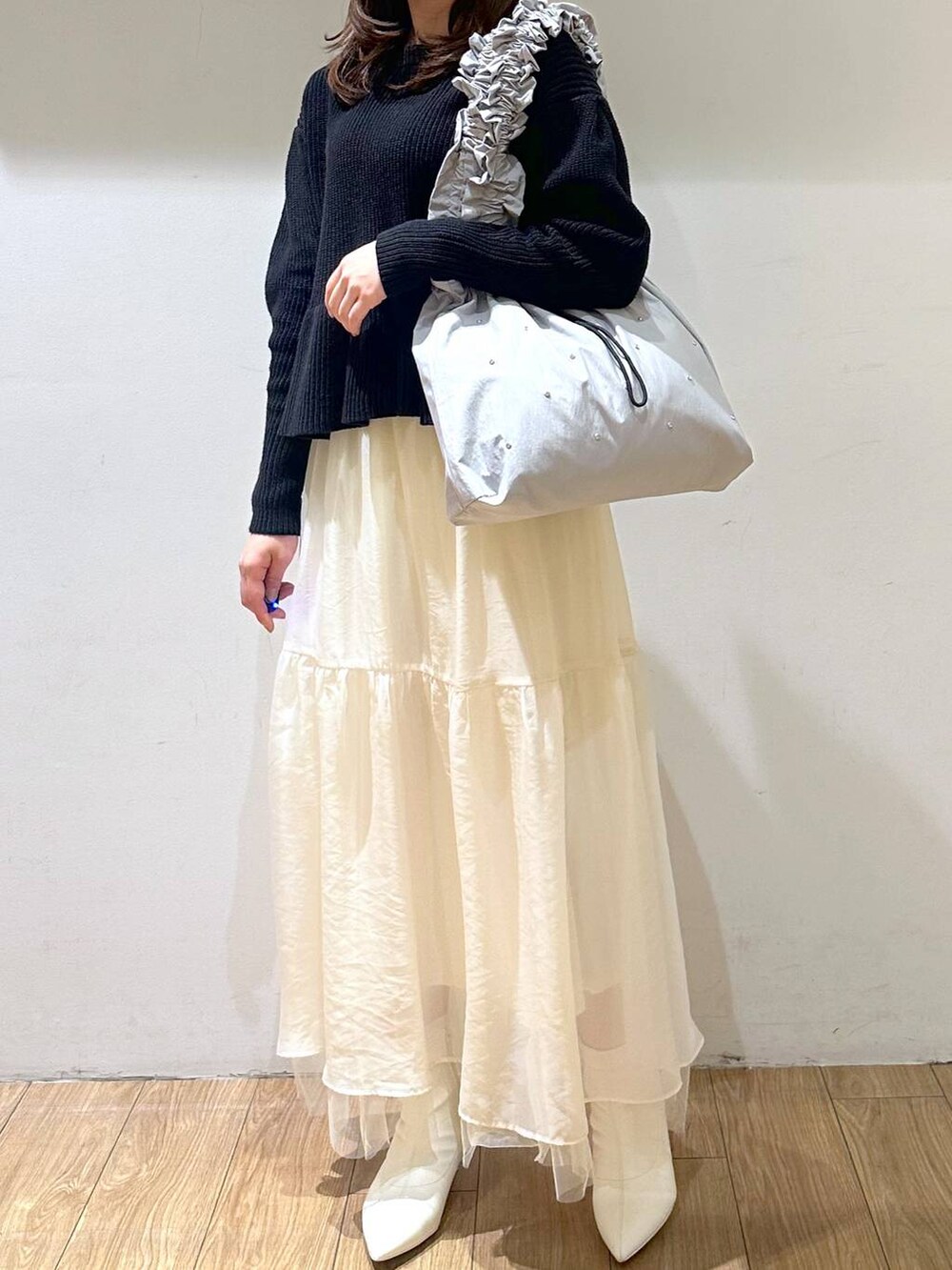 ホワイト系のブーツ、ホワイト系のスカート、グレー系のトートバッグを着用したレディースの冬コーディネートの5枚目の写真