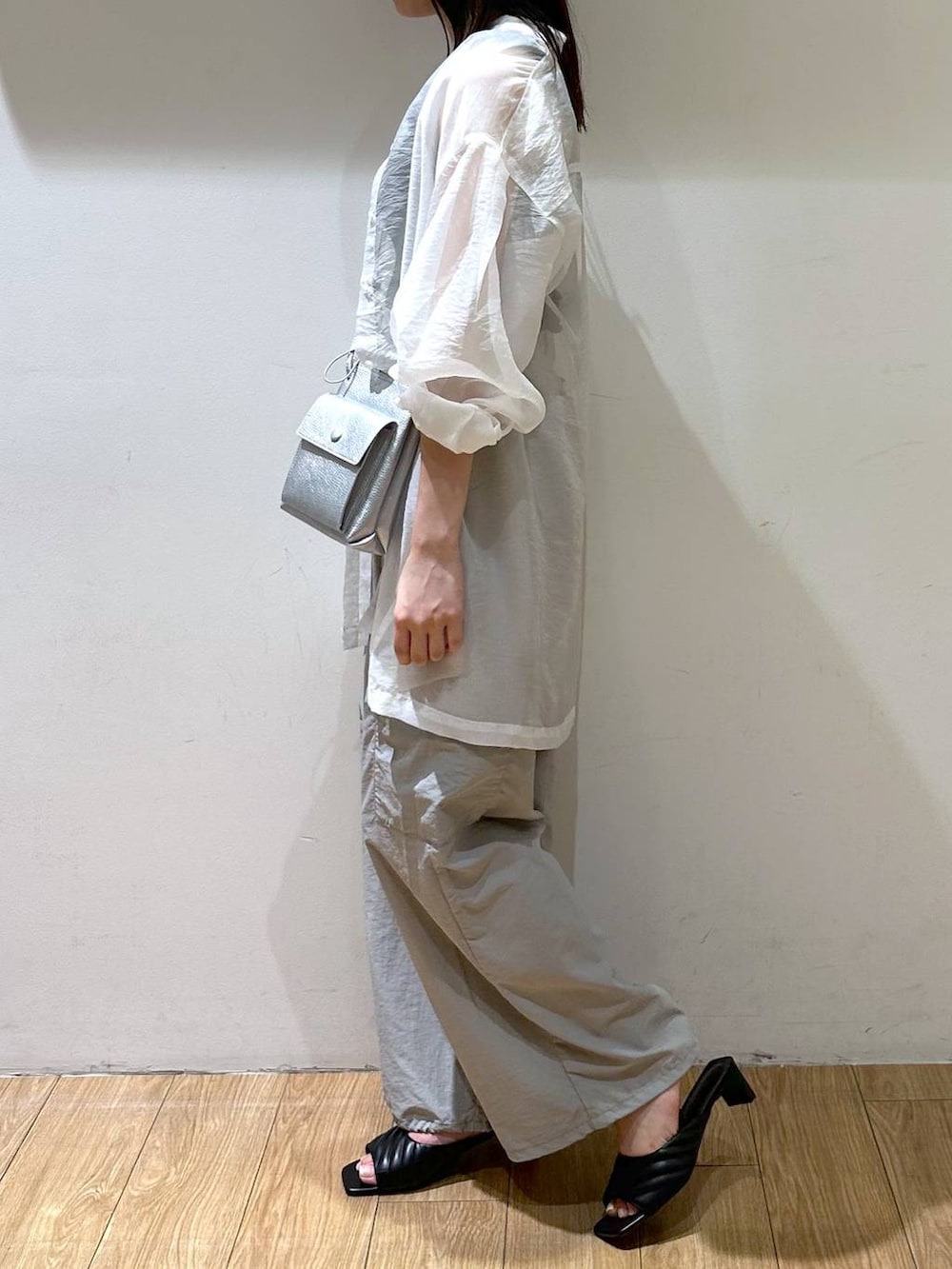 シルバー系のショルダーバッグ、グレー系のその他パンツ、ブラック系のサンダルを着用したレディースの夏コーディネートの3枚目の写真