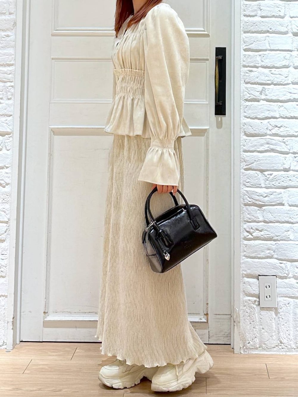 ホワイト系のシャツ/ブラウス、ホワイト系のスニーカー、ブラック系のボストンバッグを着用したレディースの秋コーディネートの3枚目の写真