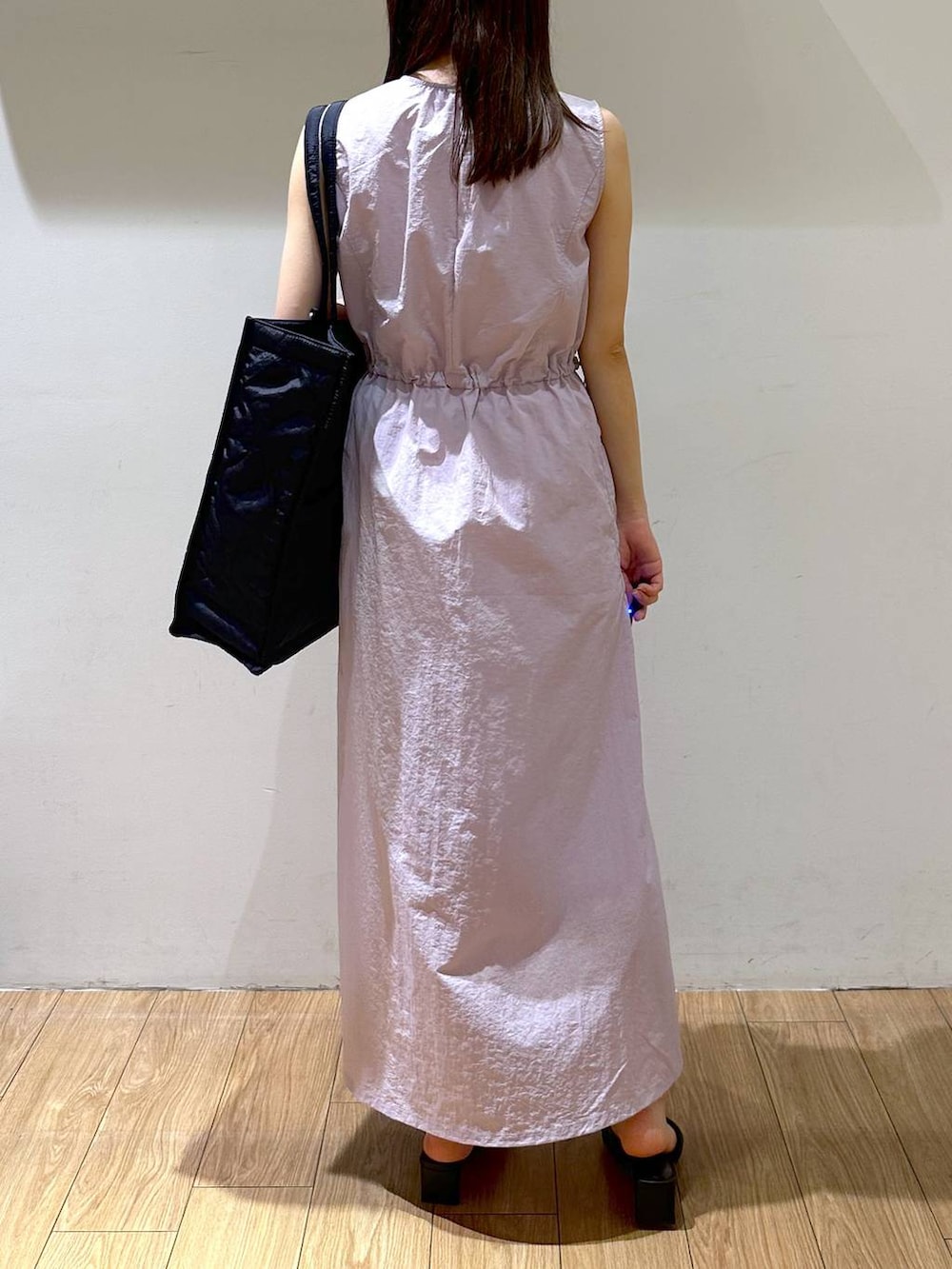 ブラック系のサンダル、パープル系のワンピース、ブラック系のショルダーバッグを着用したレディースの夏コーディネートの2枚目の写真