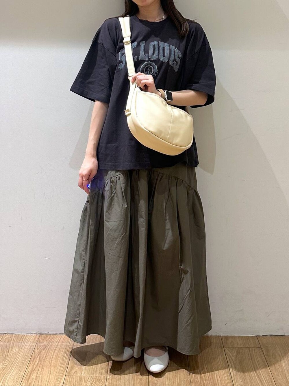 ホワイト系のパンプス、グレー系のTシャツ/カットソー、グリーン系のスカートを着用したレディースの夏コーディネートの3枚目の写真