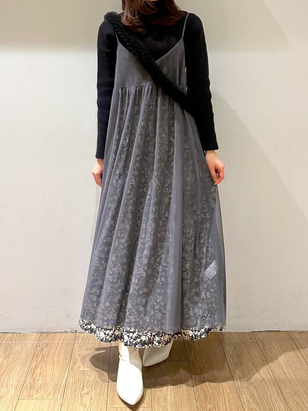 グレー系のワンピース、ホワイト系のブーツ、ブラック系のニット/セーターを着用したレディースの冬コーディネートの4枚目の写真