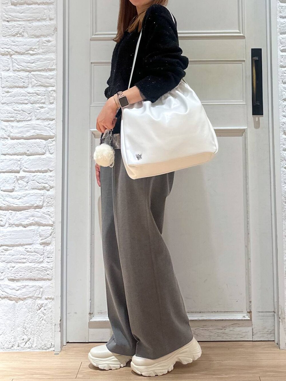 ホワイト系のブーツ、ホワイト系のショルダーバッグ、グレー系のその他パンツを着用したレディースの冬コーディネートの4枚目の写真