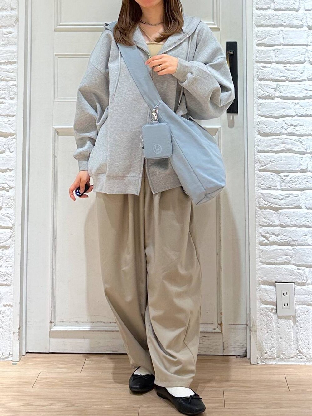ブルー系のショルダーバッグ、ベージュ系のその他パンツ、グレー系のパーカーを着用したレディースの春コーディネートの2枚目の写真