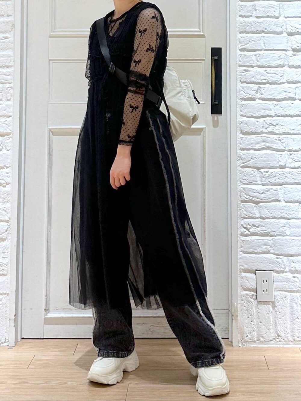 ブラック系のデニムパンツ、ホワイト系のスニーカー、ブラック系のTシャツ/カットソーを着用したレディースの秋コーディネートの4枚目の写真