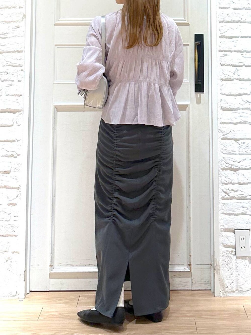 ブラック系のバレエシューズ、シルバー系のトートバッグ、グレー系のスカートを着用したレディースの春コーディネートの3枚目の写真