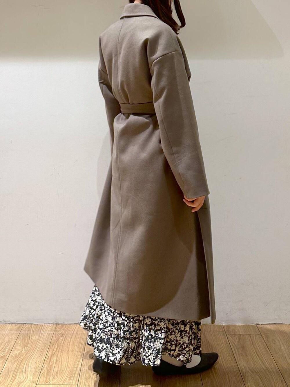 ブラック系のパンプス、ブラウン系のトレンチコート、ブラック系のニット/セーターを着用したレディースの冬コーディネートの2枚目の写真