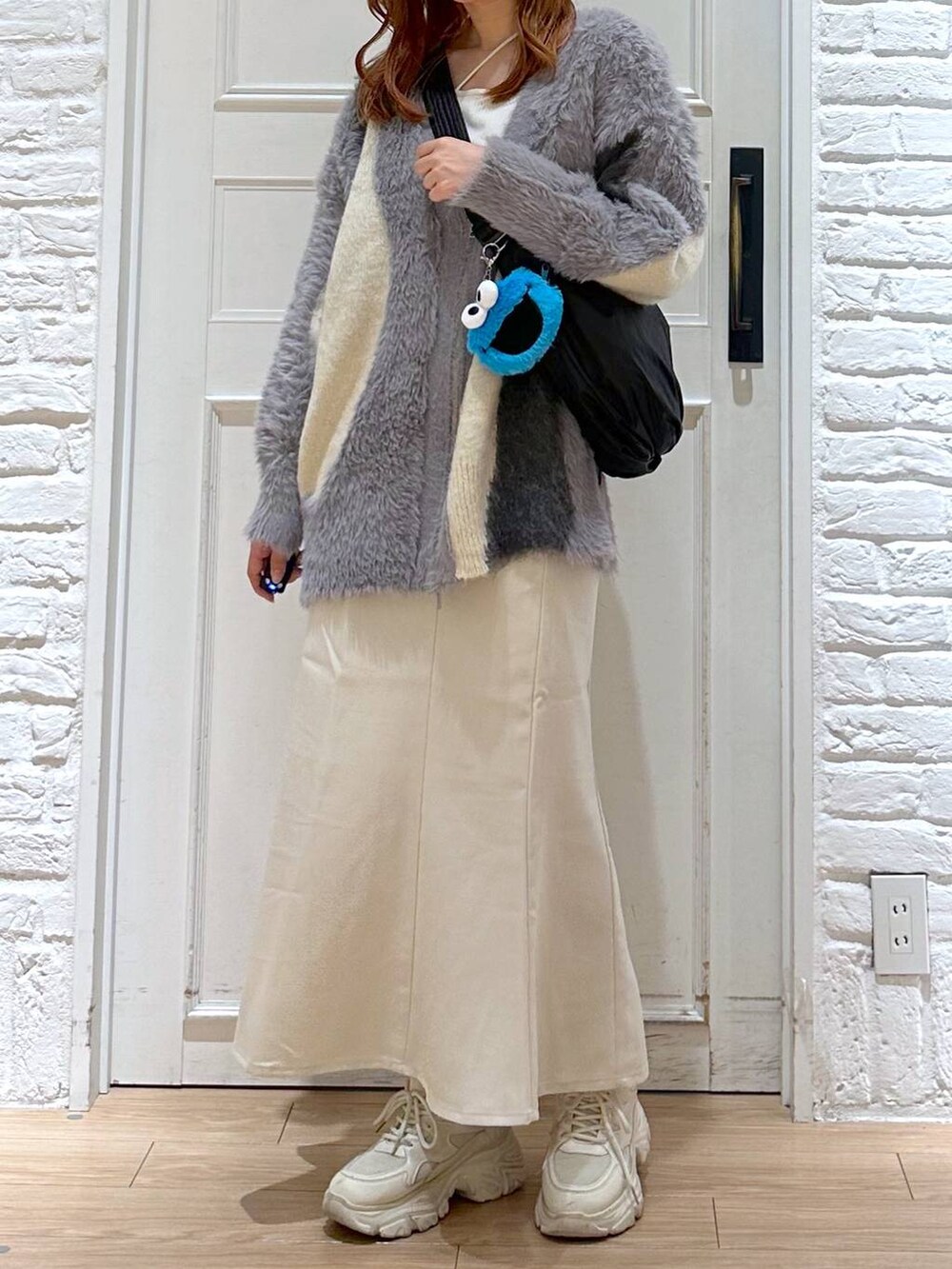 ホワイト系のスカート、ホワイト系のカーディガン/ボレロ、ホワイト系のスニーカーを着用したレディースの秋コーディネートの4枚目の写真