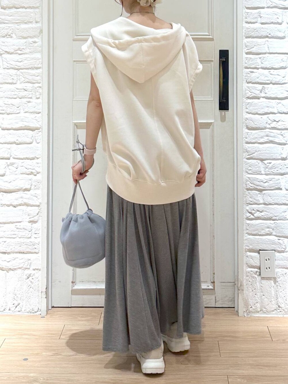 ベージュ系のキャミソール、グレー系のショルダーバッグ、グレー系のスカートを着用したレディースの夏コーディネートの3枚目の写真