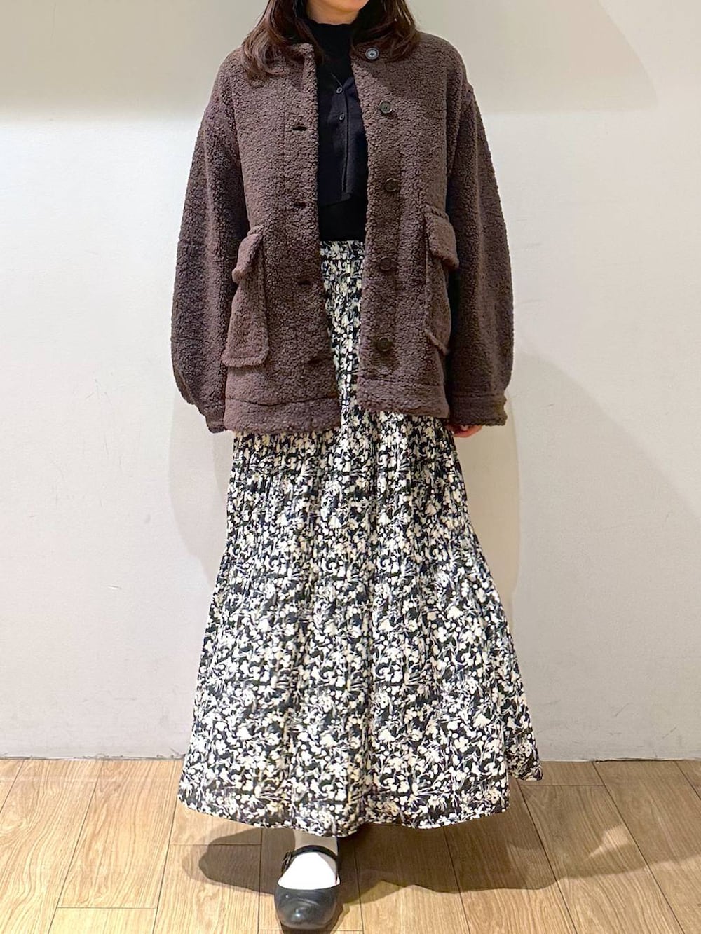 ブラック系のパンプス、ブラウン系のブルゾン、ブラック系のニット/セーターを着用したレディースの冬コーディネートの2枚目の写真