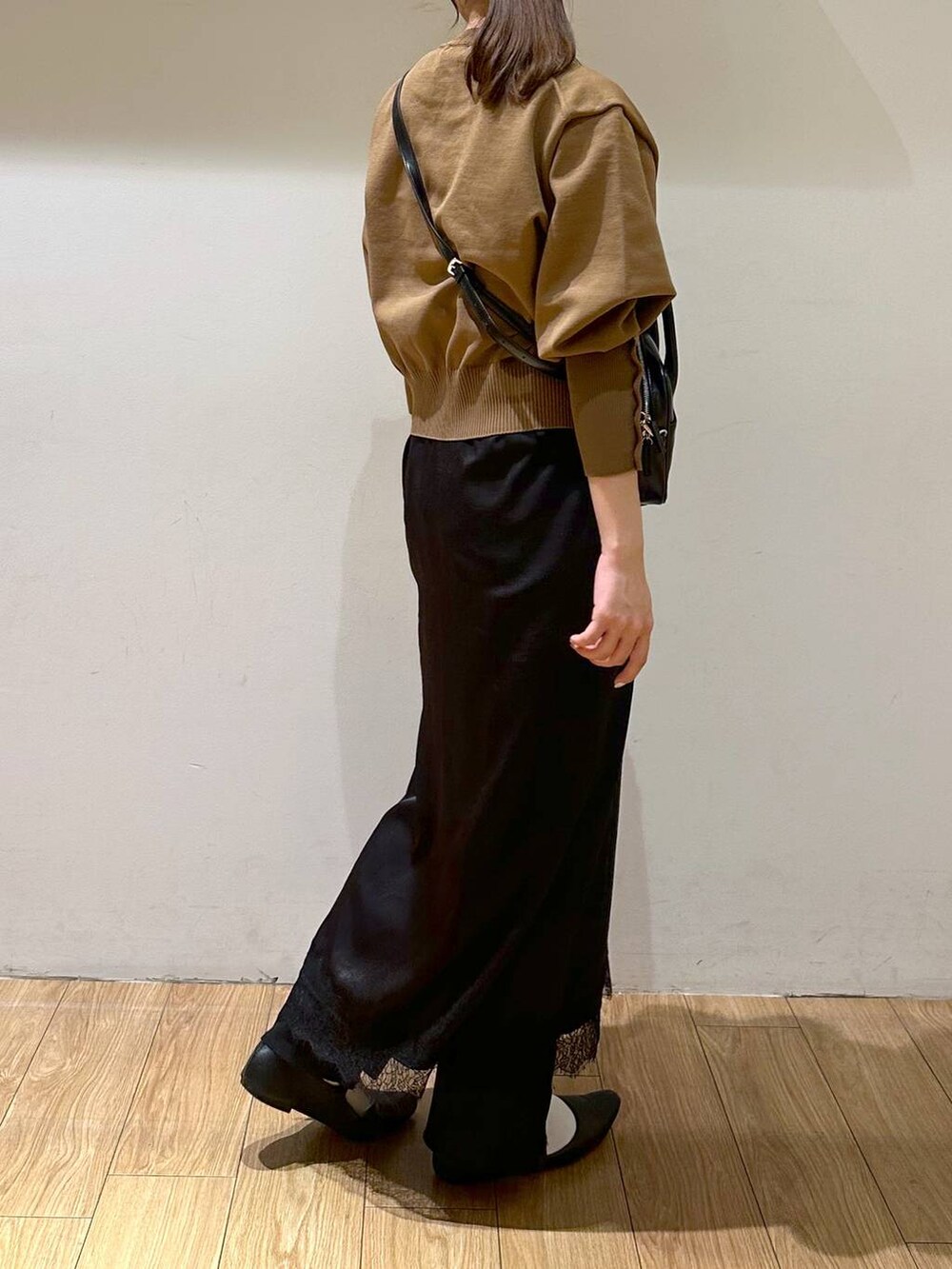 ブラック系のパンプス、ブラック系のワンピース、ベージュ系のニット/セーターを着用したレディースの秋コーディネートの5枚目の写真