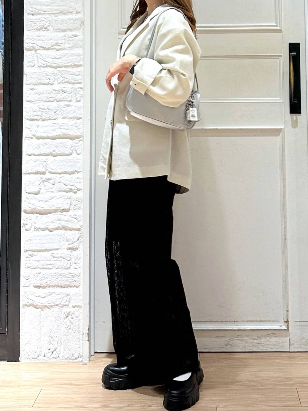 ブラック系のスニーカー、ホワイト系のテーラードジャケット、ホワイト系のTシャツ/カットソーを着用したレディースの春コーディネートの2枚目の写真