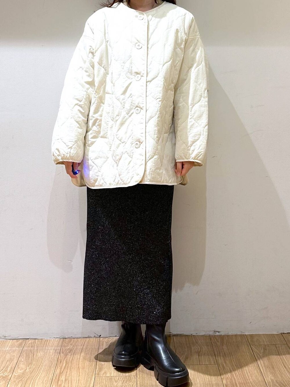 ホワイト系のブルゾン、ブラック系のブーツ、ブラック系のスカートを着用したレディースの冬コーディネートの3枚目の写真