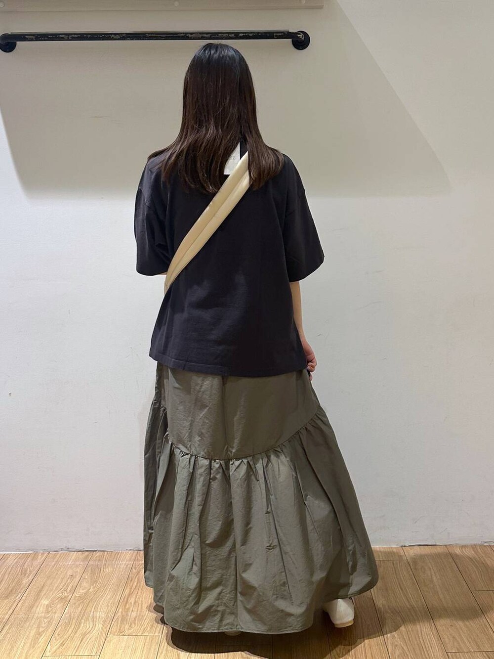 ホワイト系のパンプス、グレー系のTシャツ/カットソー、グリーン系のスカートを着用したレディースの夏コーディネートの2枚目の写真