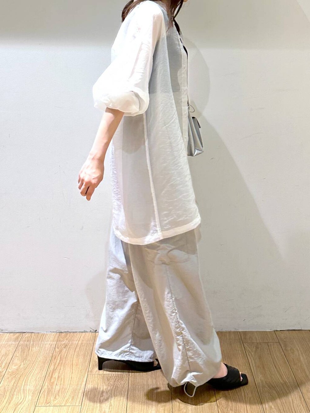 シルバー系のショルダーバッグ、グレー系のその他パンツ、ブラック系のサンダルを着用したレディースの夏コーディネートの2枚目の写真