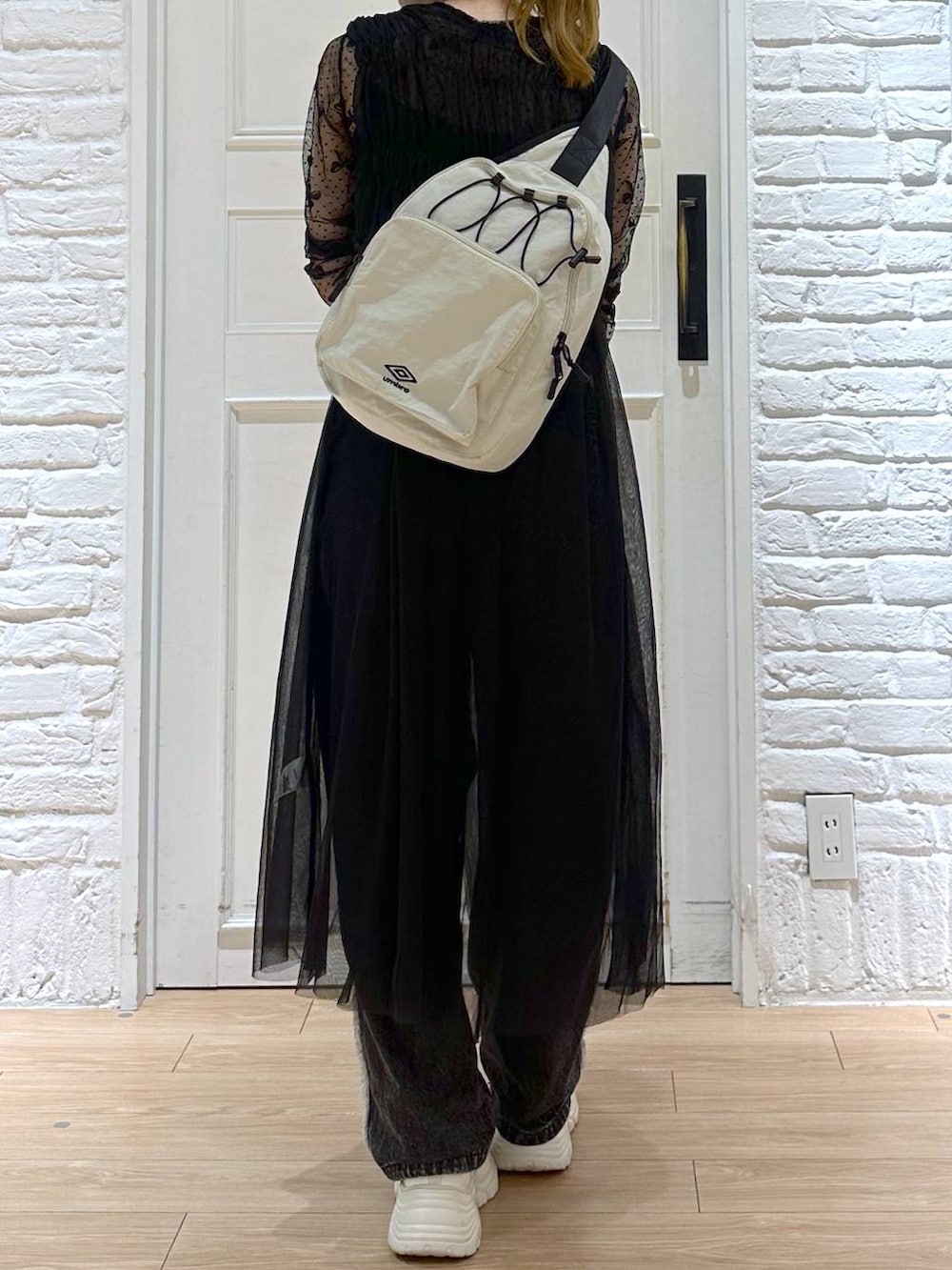 ブラック系のデニムパンツ、ホワイト系のスニーカー、ブラック系のTシャツ/カットソーを着用したレディースの秋コーディネートの7枚目の写真