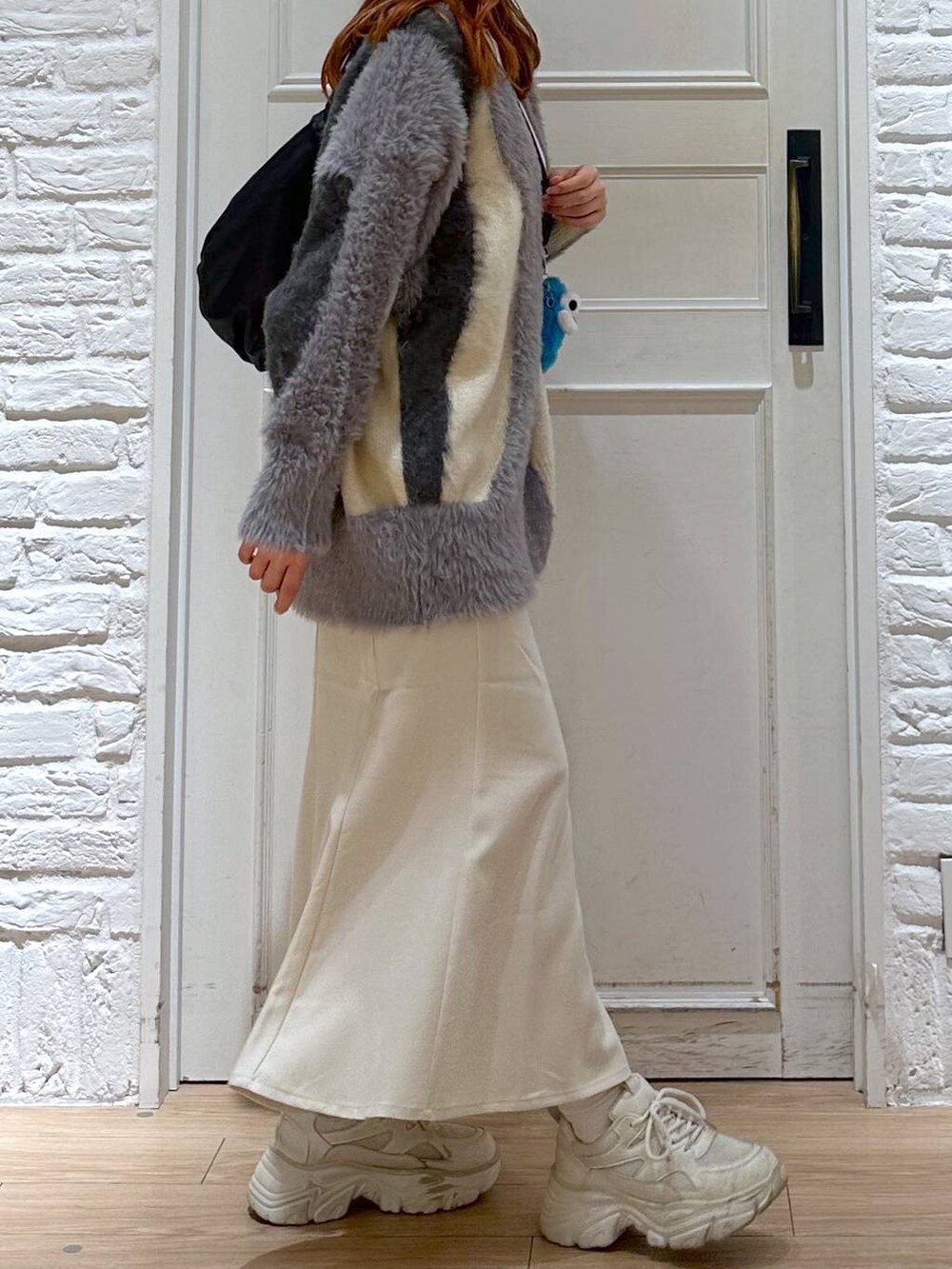 ホワイト系のスカート、ホワイト系のカーディガン/ボレロ、ホワイト系のスニーカーを着用したレディースの秋コーディネートの3枚目の写真