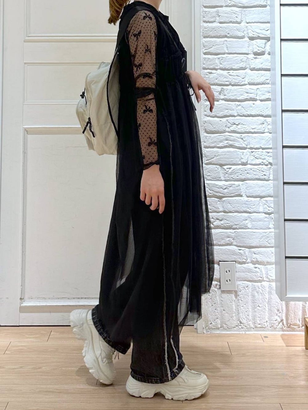 ブラック系のデニムパンツ、ホワイト系のスニーカー、ブラック系のTシャツ/カットソーを着用したレディースの秋コーディネートの5枚目の写真