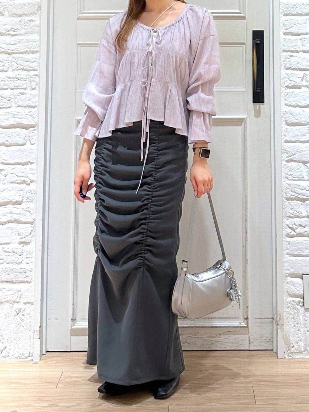 ブラック系のバレエシューズ、シルバー系のトートバッグ、グレー系のスカートを着用したレディースの春コーディネートの2枚目の写真