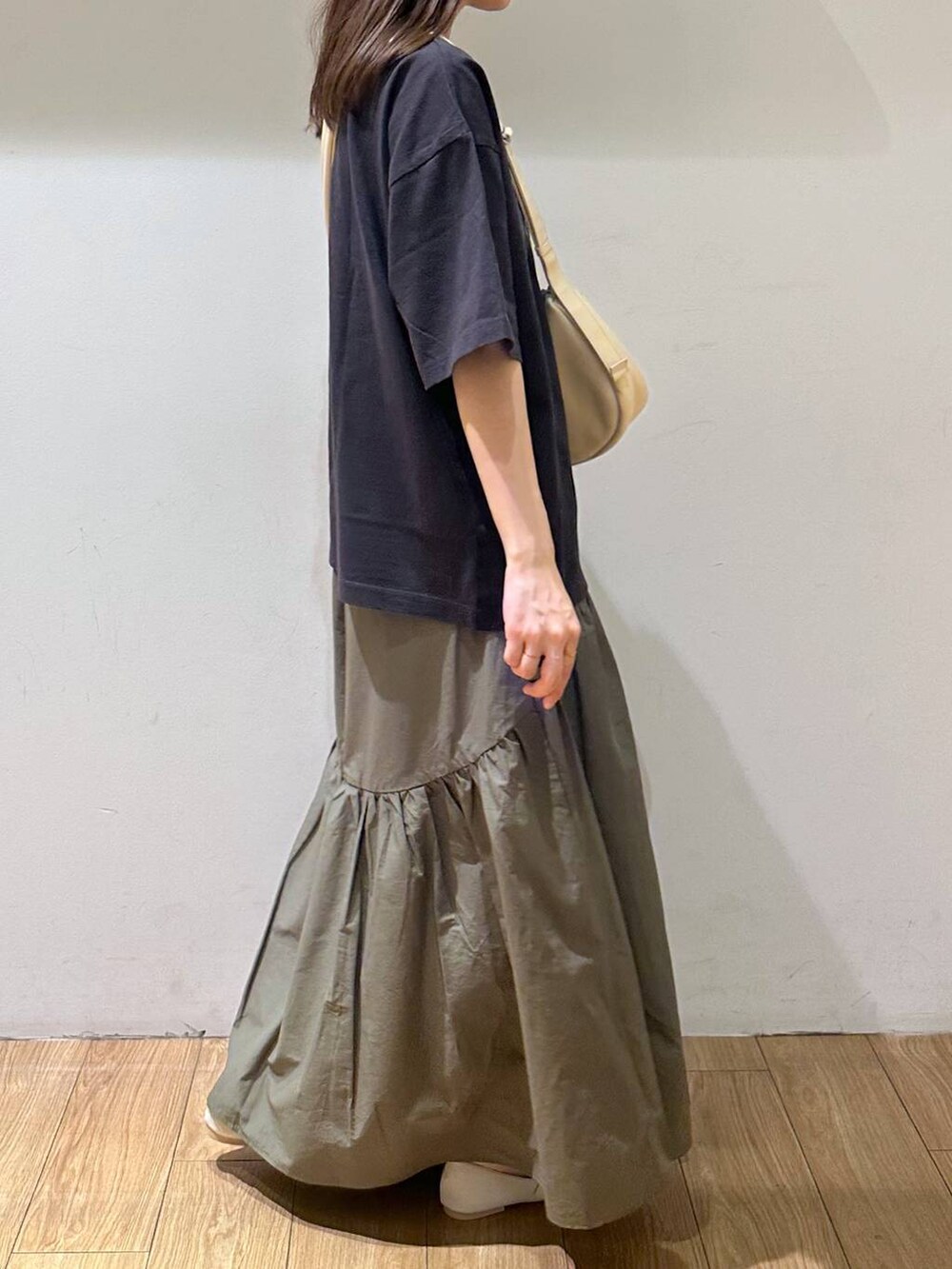 ホワイト系のパンプス、グレー系のTシャツ/カットソー、グリーン系のスカートを着用したレディースの夏コーディネートの4枚目の写真