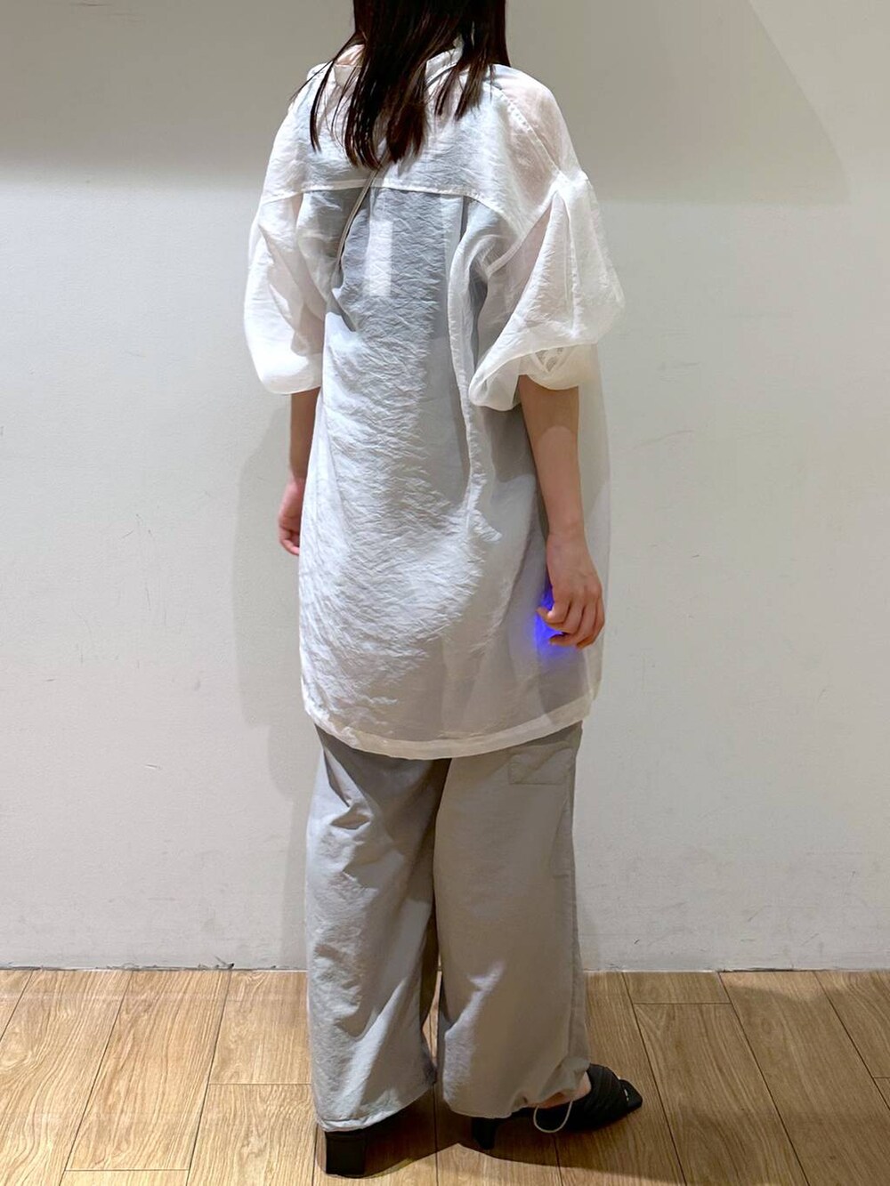 シルバー系のショルダーバッグ、グレー系のその他パンツ、ブラック系のサンダルを着用したレディースの夏コーディネートの4枚目の写真