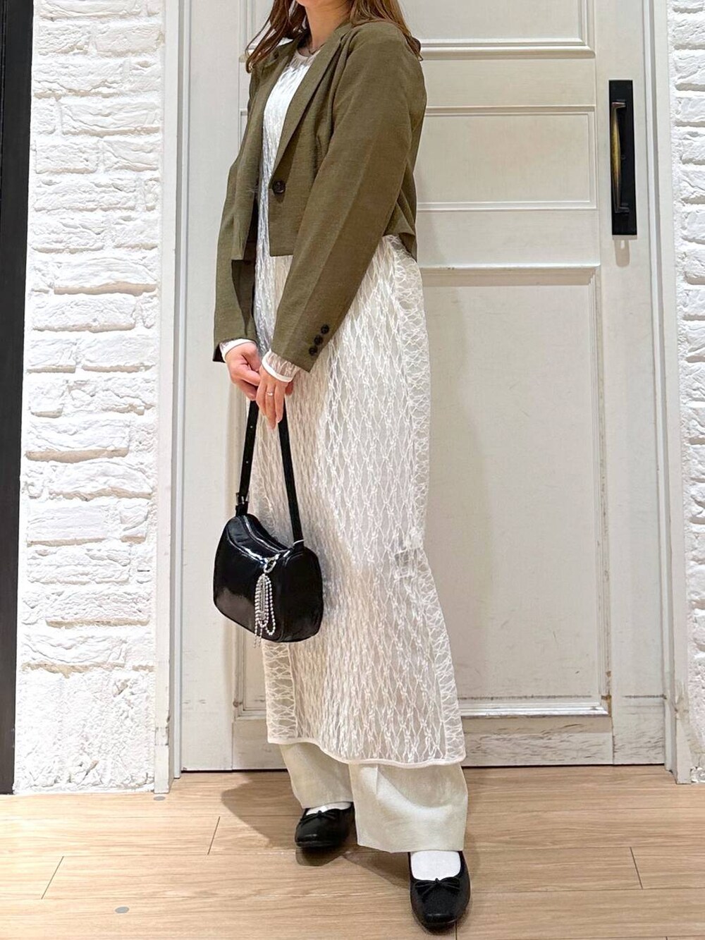 ホワイト系のスラックス、ブラウン系のテーラードジャケット、ホワイト系のTシャツ/カットソーを着用したレディースの春コーディネートの2枚目の写真