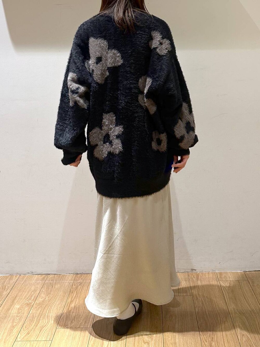 ブラック系のパンプス、ブラック系のニット/セーター、ホワイト系のスカートを着用したレディースの冬コーディネートの4枚目の写真