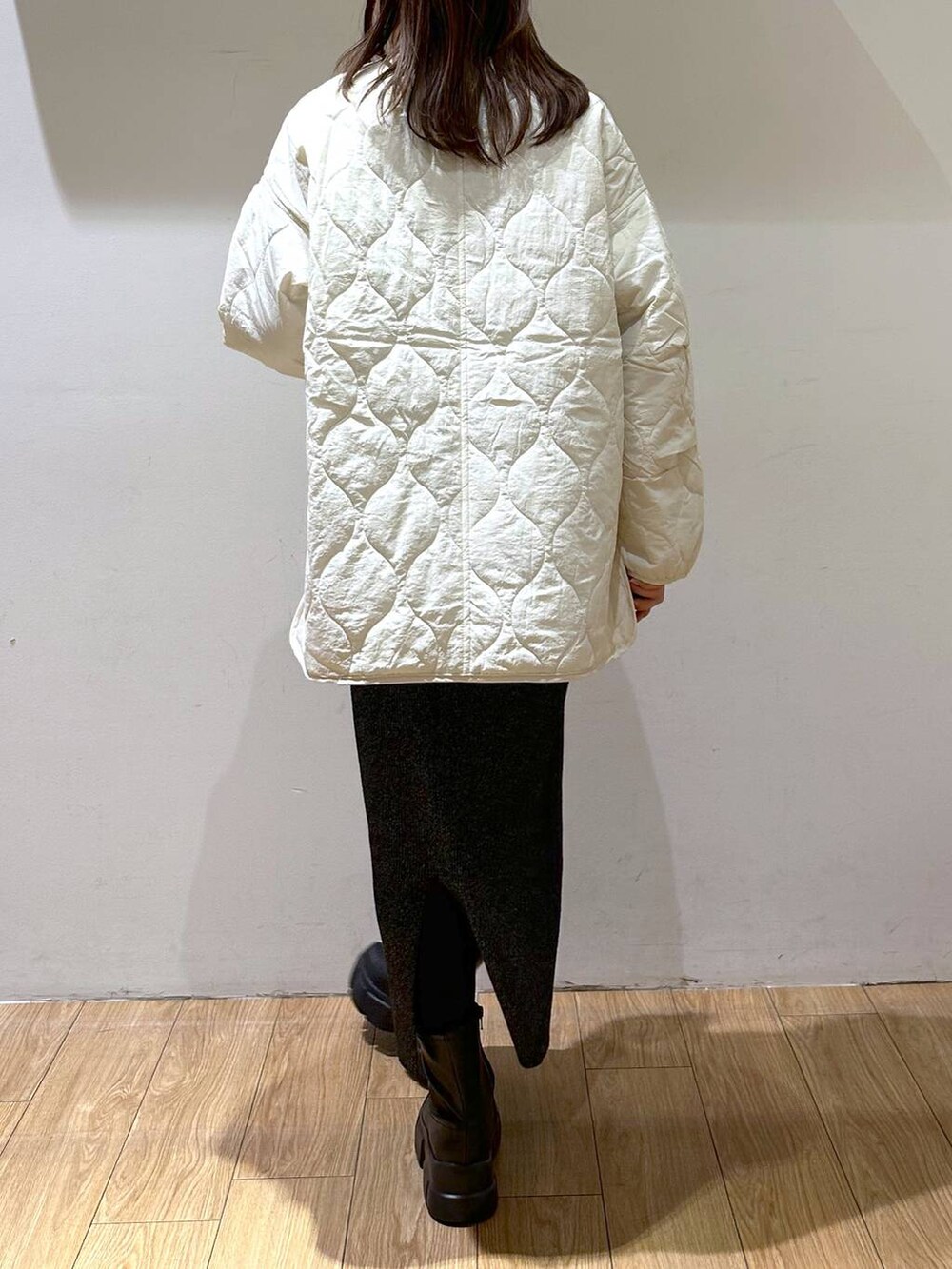 ホワイト系のブルゾン、ブラック系のブーツ、ブラック系のスカートを着用したレディースの冬コーディネートの5枚目の写真