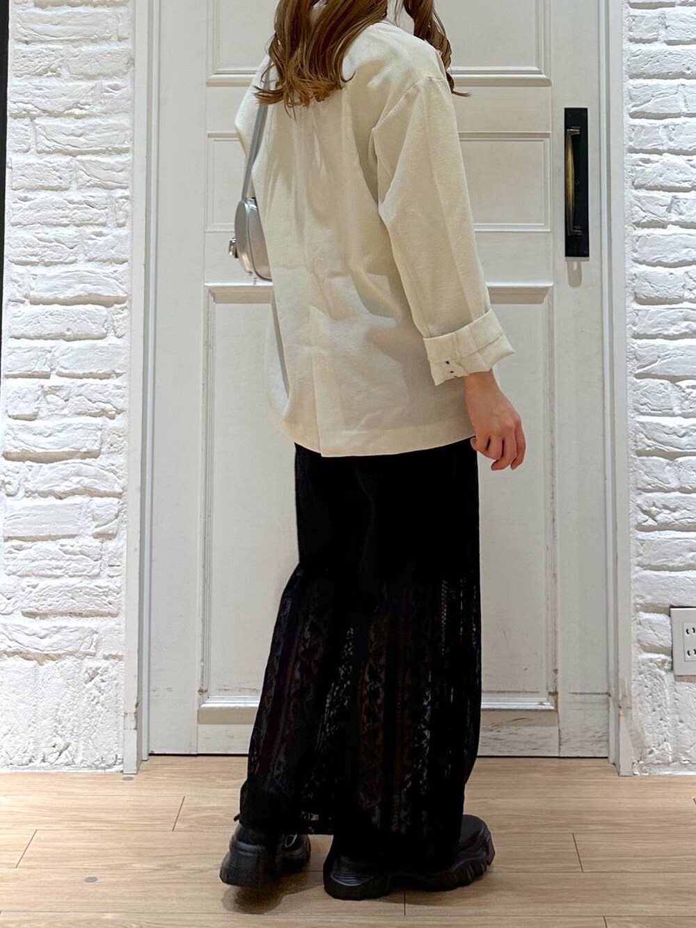 ブラック系のスニーカー、ホワイト系のテーラードジャケット、ホワイト系のTシャツ/カットソーを着用したレディースの春コーディネートの4枚目の写真