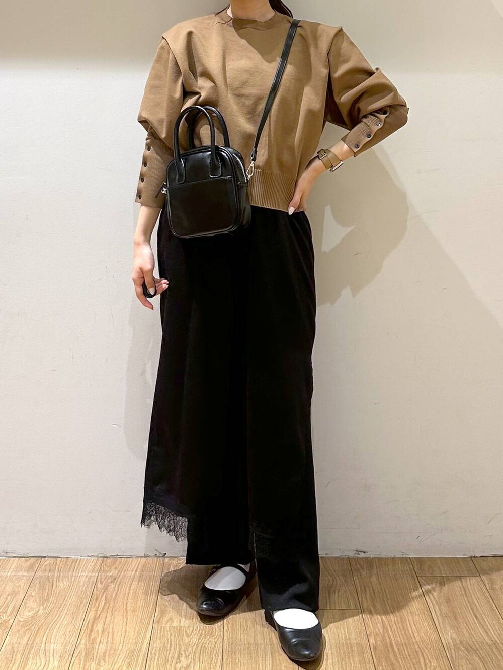 ブラック系のパンプス、ブラック系のワンピース、ベージュ系のニット/セーターを着用したレディースの秋コーディネートの2枚目の写真