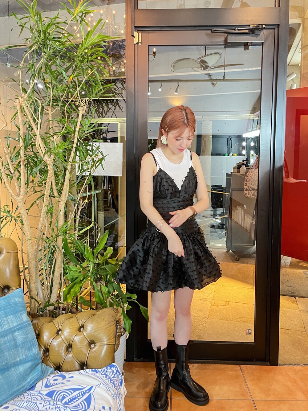 ブラック系のワンピース、ブラック系のブーツ、ホワイト系のタンクトップを着用したレディースの秋コーディネートの2枚目の写真