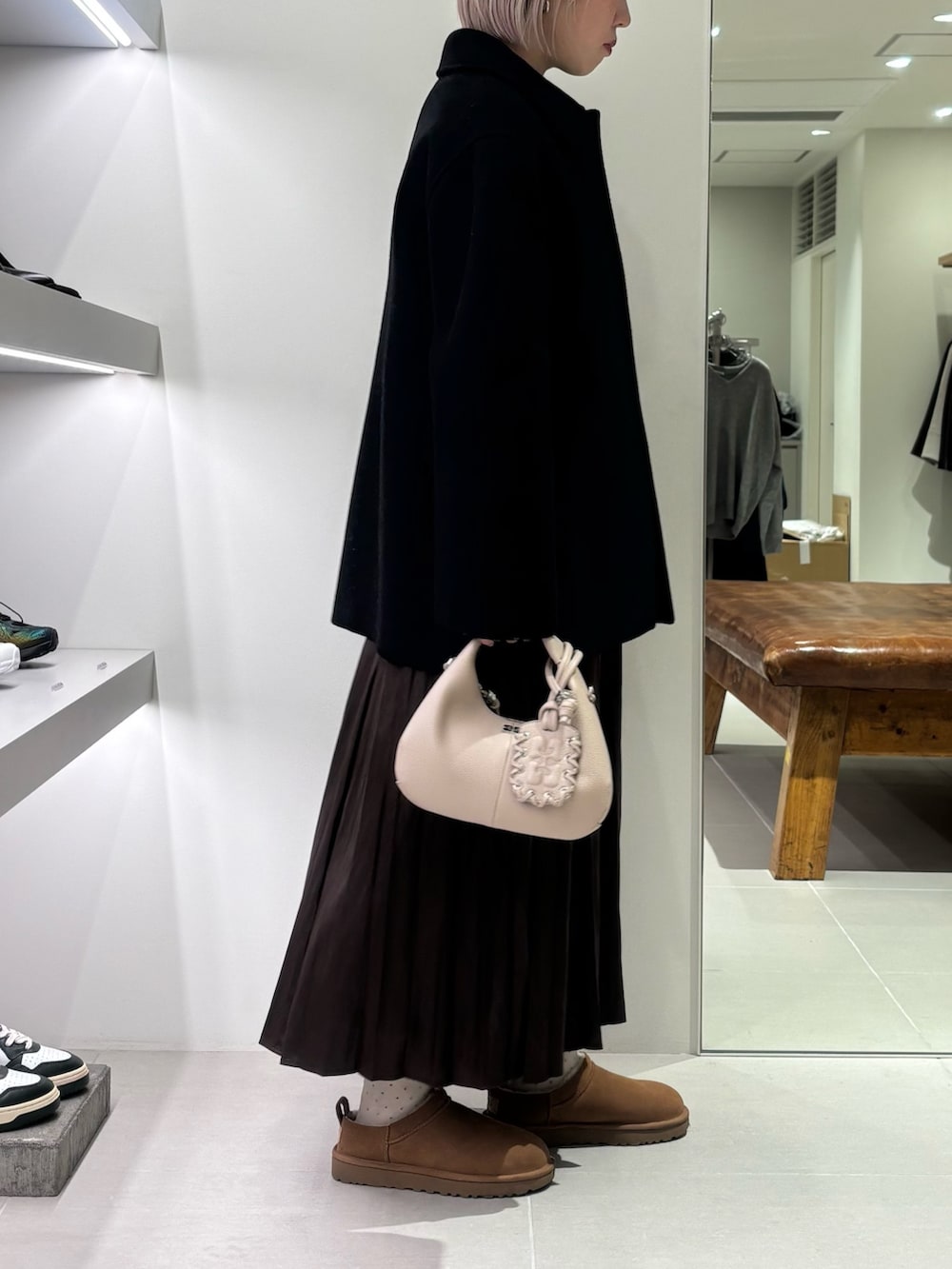 ブラック系のテーラードジャケット、グレー系のニット/セーター、ブラウン系のスカートを着用したレディースの秋コーディネートの2枚目の写真