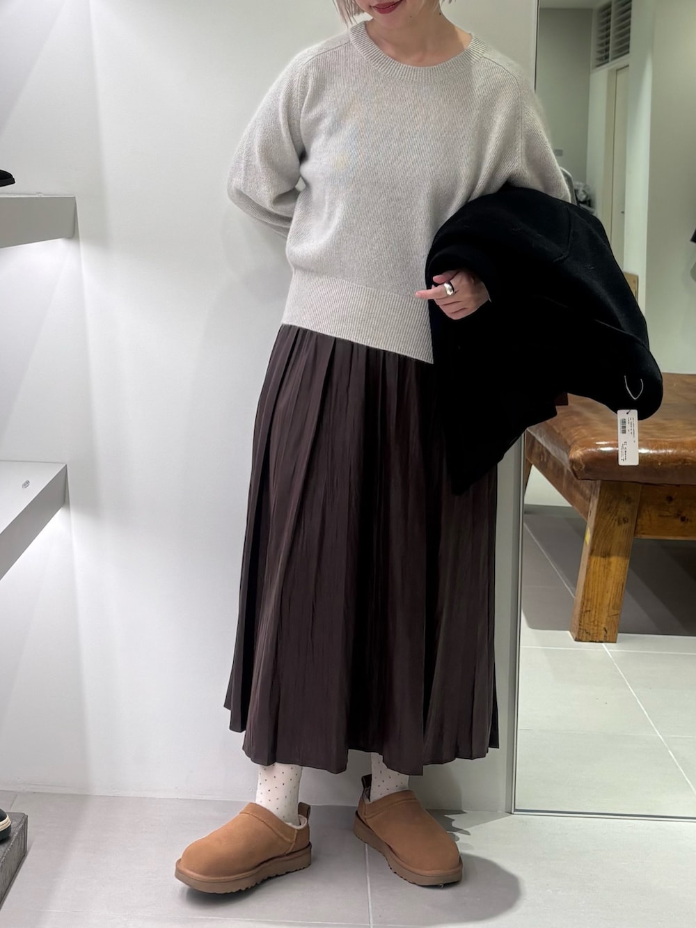 ブラック系のテーラードジャケット、グレー系のニット/セーター、ブラウン系のスカートを着用したレディースの秋コーディネートの4枚目の写真