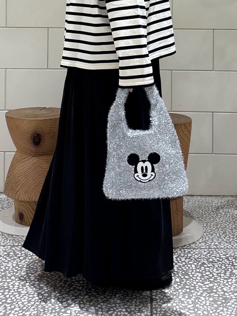 ブラック系のブルゾン、ホワイト系のTシャツ/カットソー、ブラック系のスカートを着用したレディースの秋コーディネートの3枚目の写真