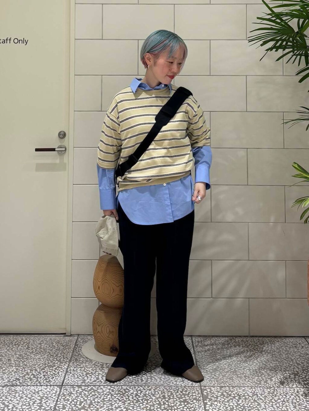 ブラック系のその他パンツ、ブルー系のシャツ/ブラウス、ブラック系のバックパック/リュックを着用したレディースの春コーディネートの2枚目の写真