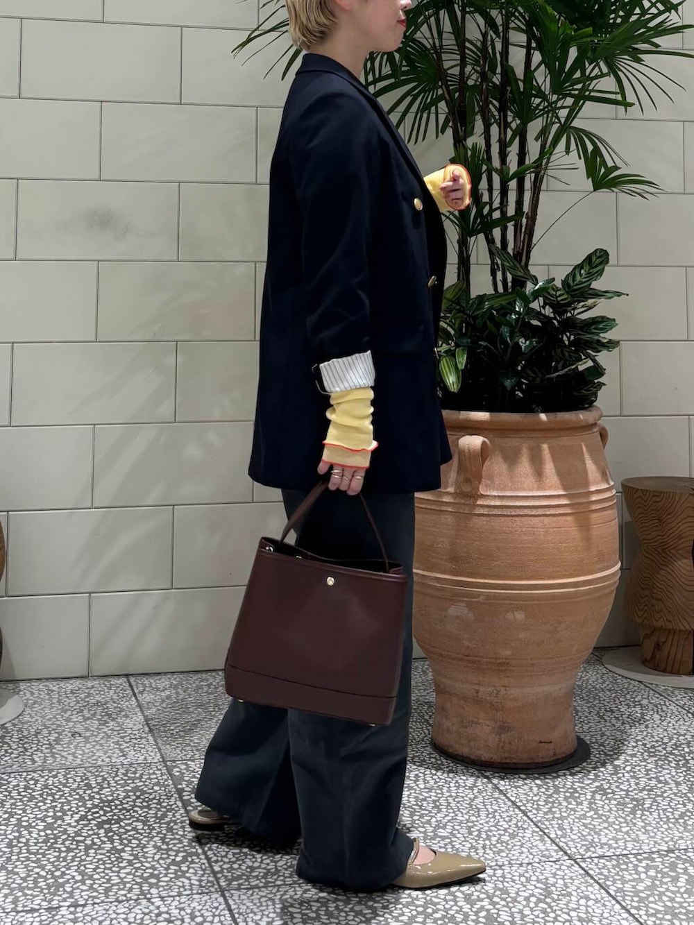 ブルー系のその他アウター、グレー系のその他パンツ、ブラウン系のハンドバッグを着用したレディースの冬コーディネートの2枚目の写真